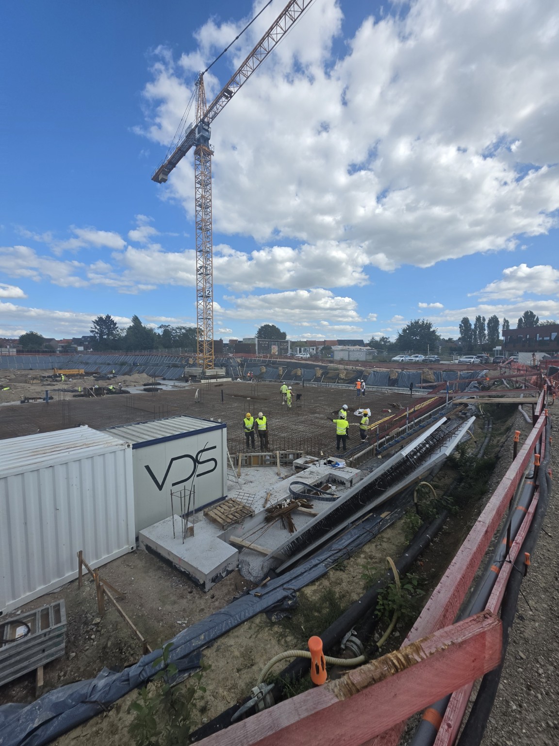 Stored reinforcement and access routes alongside the work area.